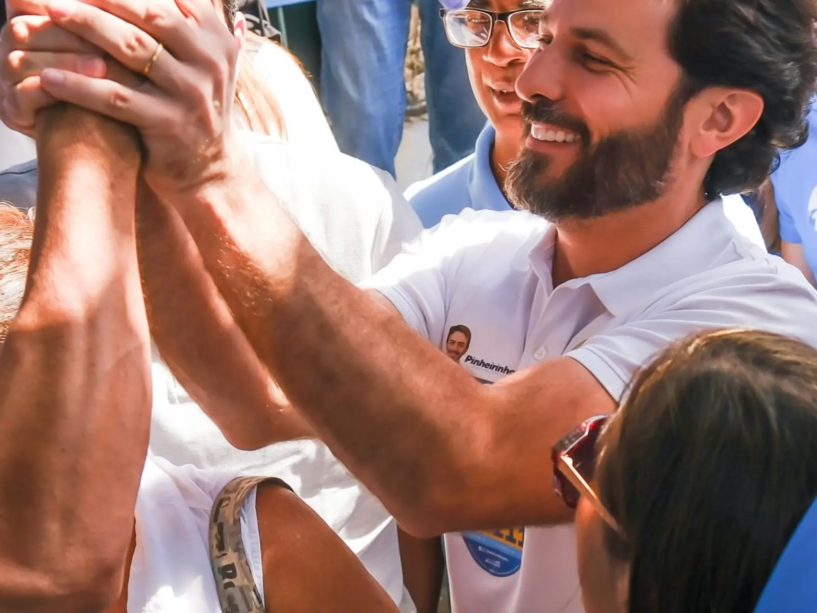 Marcelo Aro cumprimentando apoiadores durante encontro público.